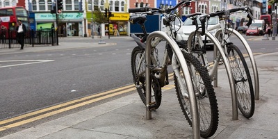 Two bikes locked to a frame infront of a road