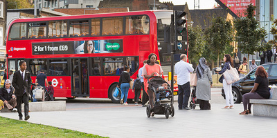 Busy London street with a red bus driving by