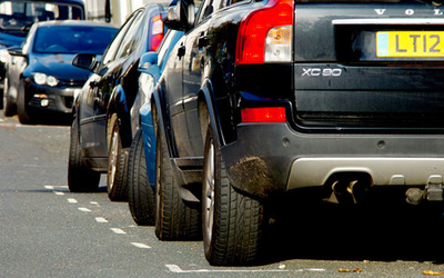 two cars parked within a white dotted-lined parking bay 